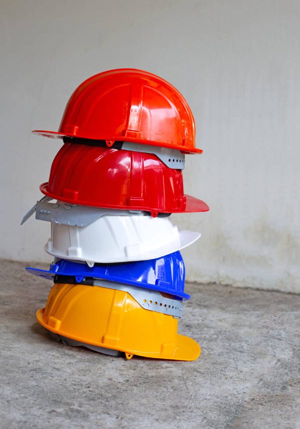 Construction helmets on concrete background.